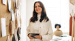 © (JLco) Julia Amaral - Creative small business owner holding a digital tablet and looking away