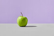 green apple on a gray-violet background. Stylish vegan concept