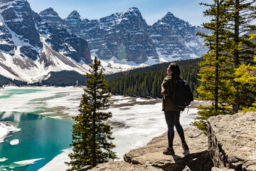 Woman tourist backpacker viewing the beautiful landscape of banff national park. Icy mountains. Tourist hiking.