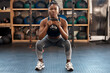 © Sivu G/peopleimages.com - Exercise, fitness and kettlebell with woman squat, workout and gym challenge with weight. African female person, strength training and wellness with sport for muscle and athlete in a health center