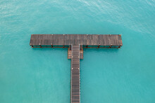 Drone Aerial Of Pier In The Ocean. Empty Dock Blue Turquoise Ocean Water