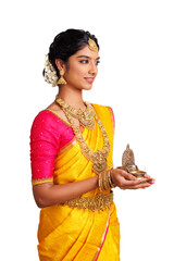 Wall Mural - Beautiful happy Indian young woman in saree holding Deepa (oil lamp ) isolated on white.	
