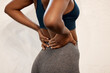 © Sivu G/peopleimages.com - Back pain, fitness and closeup of black woman in gym for muscle, ache and inflammation. Healthcare, emergency and accident with body of female athlete for burnout, sports injury and spine problem