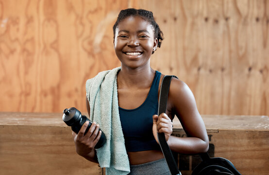 Happy black woman, portrait and fitness for workout, exercise or cardio training at the gym. Fit, active or sporty African female person or athlete with smile and towel for healthy wellness indoors