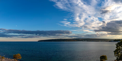 Wall Mural - Panoramic view at sea bay and cloudy sunset sky.