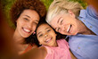 © Monkey Business - POV Overhead Shot Of Multi-Generation Female Family Lying On Grass Taking Selfie On Mobile Phone