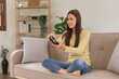 © Pichsakul - Relaxation concept, Young woman sitting on the couch to control joystick while playing video games