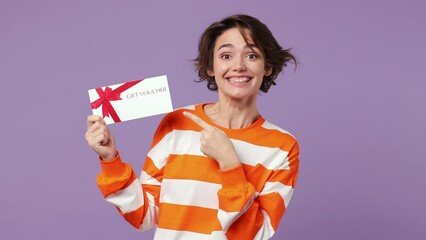 Wall Mural - Surprised shocked happy young caucasian woman wear casual clothes pointing finger on gift certificate coupon voucher card for store do winner gesture isolated on plain pastel light purple background