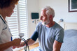 © Monkey Business - Female Nurse Wearing Uniform Taking Blood Pressure Of Senior Man In Private Hospital Room