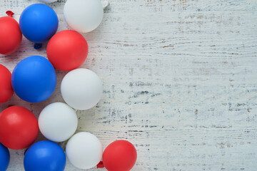 4th of July background. USA paper fans, Red, blue, white stars,  balloons, gold confetti on white wooden  background. Happy Labor Day, Independence or Presidents Day. American flag colors. Top view.