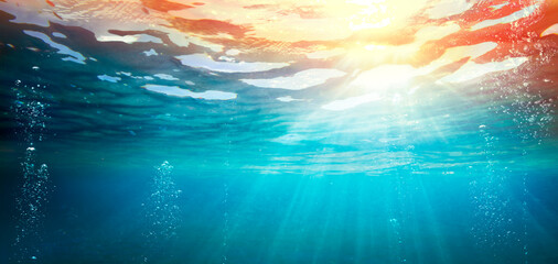 Wall Mural - underwater ocean with sunset - abyss with sunlight - abstract defocused background and glowing effec
