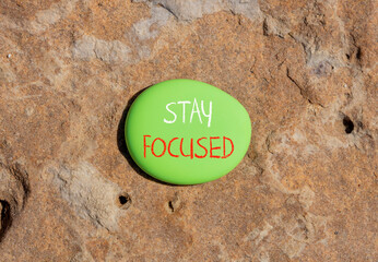 Stay focused symbol. Concept words Stay focused on beautiful green stone on a beautiful stone sea beach background. Business, support, motivation, psychological and stay focused concept. Copy space.