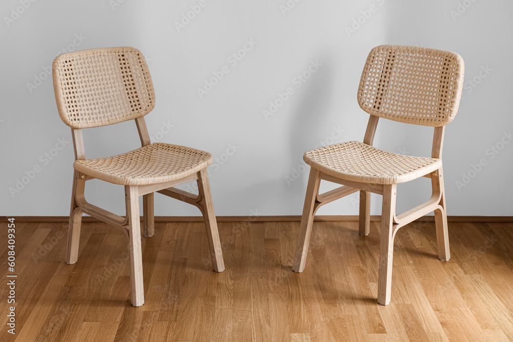 Wicker chairs near light wall