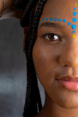 Wall Mural - Close-up portrait of a beautiful black woman with colorful paint on her face.