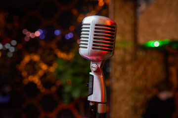 Wall Mural - Retro Microphones on front stage in pub bar or restaurant. Classic sing a song in evening and night show concert light bokeh background.