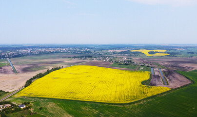 Wall Mural - Aerial view of the yellow agricultural agro fields of rapeseed plant culture. Photography for the background of tourism, design, advertising and agro business