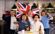 © JackF - Company of joyful sports supporters waving flag of Great Britain and celebrating victory of favotite team in pub