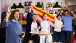 © JackF - Excited sports supporters of different ages with flag of Estelada, rejoicing winning game with beer and snacks in pub