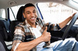 © Home-stock - Happy black man sitting in new car and showing thumbs up sign gesture, buying modern vehicle in dealership store, smiling at camera