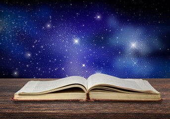 Poster - Open antique old book on table with night sky