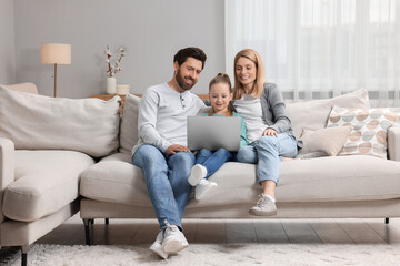 Canvas Print - Happy family with laptop on sofa at home