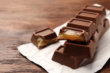 Wall Mural - Tasty chocolate bars on wooden table, closeup. Space for text