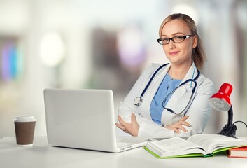 Wall Mural - Young female doctor work on laptop computer