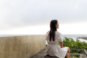 Wall Mural - Woman sit outside enjoy the sea view