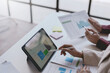 © amnaj - Business people meeting explaining the financial graph data and marketing plan on tablet. Group of business people at meeting assessment the state of business investment and marketing.