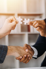 Cropped shot of Businesswoman hand connecting jigsaw puzzle with sunlight effect, Business solutions, success, and Assembling jigsaw pieces, strategy ideas.