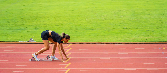 Asian young sportswoman sprint on a running track outdoors on stadium