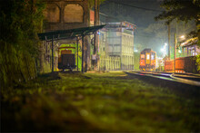 A Yellow Diesel Train Pulls Into The Station At Night With Lights On. Jingtong Station Is The Last Station Of Pingxi Line, Which Was Built In 1929.