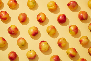 Wall Mural - Colorful fruit pattern of fresh peaches (prunus persica) on yellow background. Creative background for advertising and branding for cosmetic or product with ingredient from peach