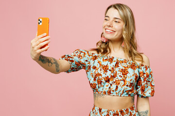 Wall Mural - Young caucasian woman wear summer casual clothes doing selfie shot on mobile cell phone post photo on social network isolated on plain pastel light pink background studio portrait. Lifestyle concept.