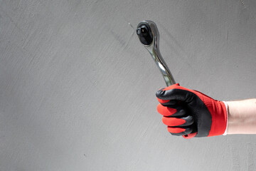 Working tools for repair. Man in denim holding yellow wrench in his hands. Front view