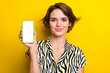 Leinwandbild Motiv Portrait of adorable lovely lady wear trendy clothes showing empty space modern device display isolated on yellow color background
