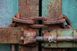 Rusty old chain on metal door and slide lock