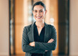 © Samir H/peopleimages.com - Portrait, smile and arms crossed with a professional business woman in her corporate workplace. Happy, vision and confident with a happy female employee standing in her office wearing a power suit