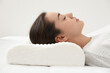 © New Africa - Woman sleeping on memory foam pillow indoors