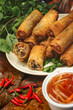 Spring rolls - fried Vietnamese rolls of rice edible paper  next to cup with sauce.