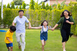 © NVB Stocker - Beautiful asian family having fun running outdoors and smiling at backyard Lawn
