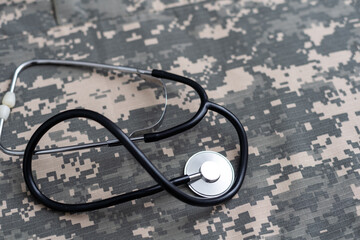 Closeup of a doctors stethoscope laying on old Military camouflage background