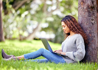 Canvas Print - Woman, student and typing on laptop at a park outdoor for education, research or studying. African person at university or college campus tree in nature with tech for knowledge, internet and learning