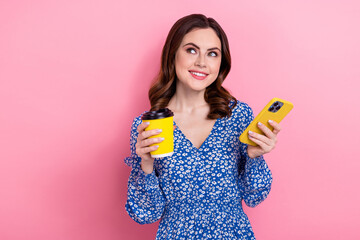 Poster - Portrait of charming lovely person hold smart phone fresh coffee cup look empty space isolated on pink color background