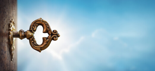 Fototapete -  Old key in a keyhole on sky background, macro photo. Retro style. The key to knowledge. Concept and idea for history, education, business, security, secret background.