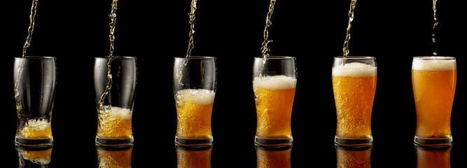 Wall Mural - Pouring beer into a glass on a black background.