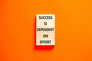 Wall Mural - Success and effort symbol. Concept words Success is dependent on effort on wooden block. Beautiful orange table orange background. Business success and effort concept. Copy space.