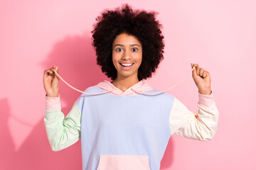 Poster - Photo of cheerful schoolchild toothy smile good mood hands hold playing hoodie laces isolated on pink color background