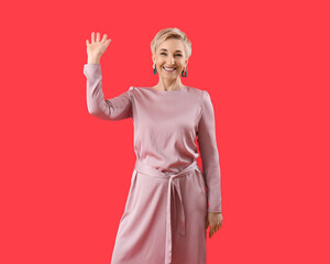 Sticker - Stylish mature woman waving hand on red background