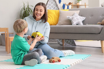 Poster - Nanny and little boy playing with toy cars at home